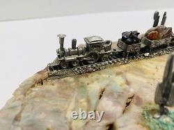 Vintage miniature pewter train set with track diorama on rock