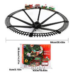 Ensemble de train électrique de Noël avec piste autour de l'arbre, musique, lumière et Père Noël
